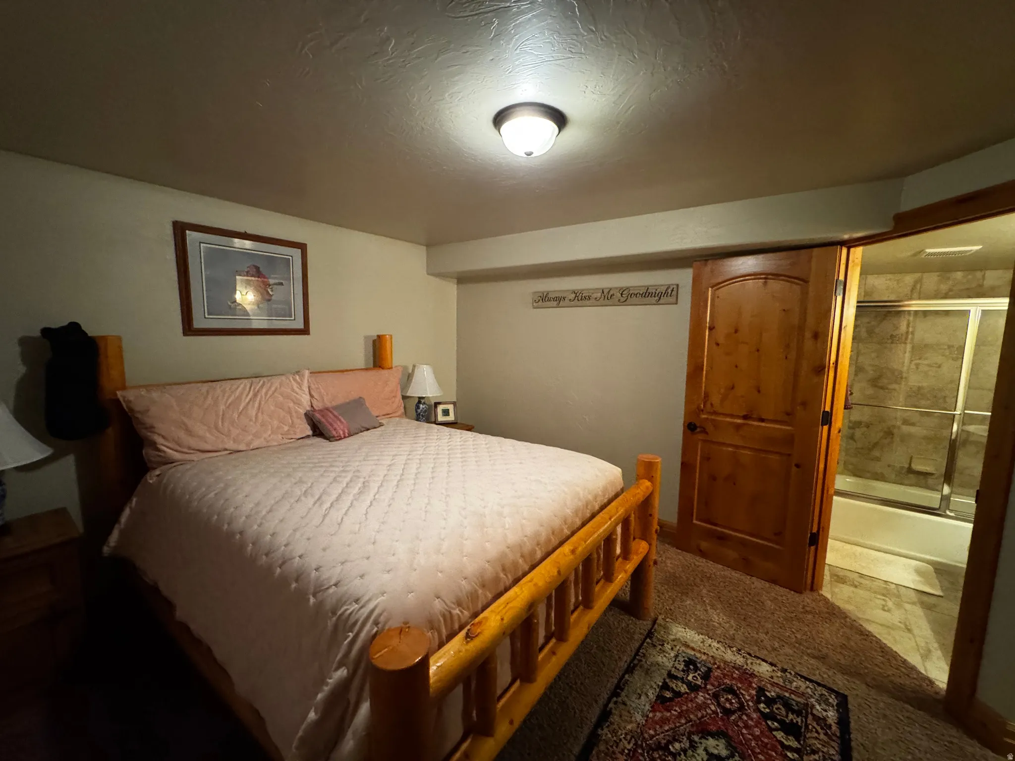 Carpeted room with a solid wood door opening to a bathroom featuring a shower-over-tub combination with tiled surround