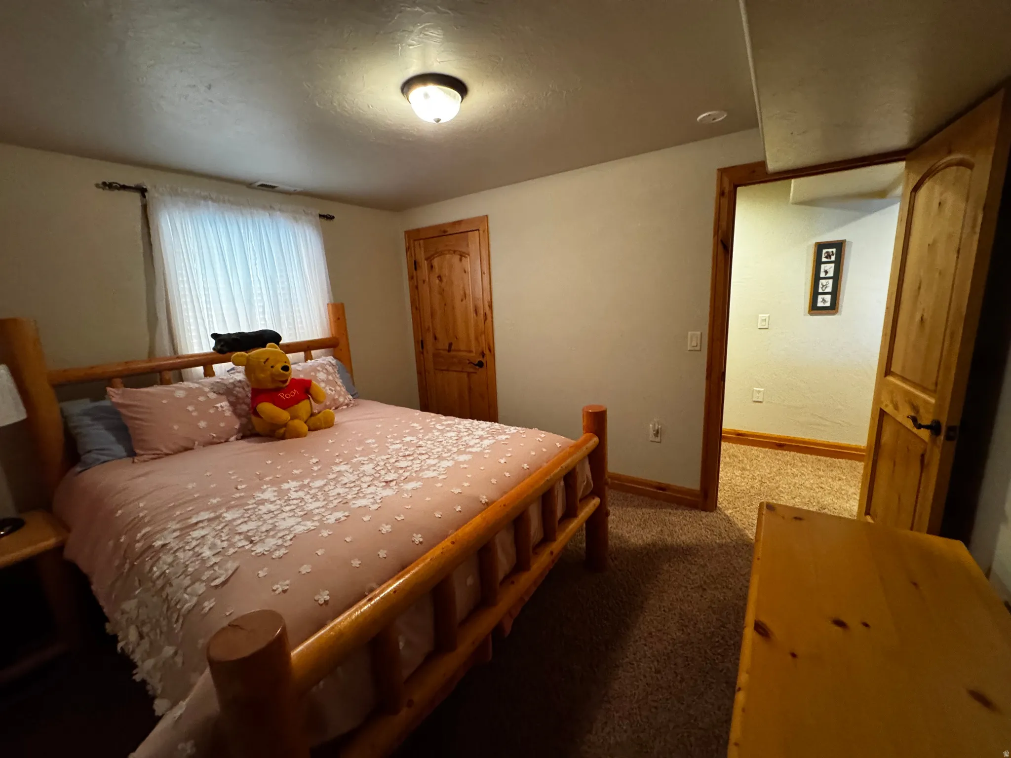 Bedroom featuring neutral wall colors, light-colored wood-finish trim, and a window with white window coverings