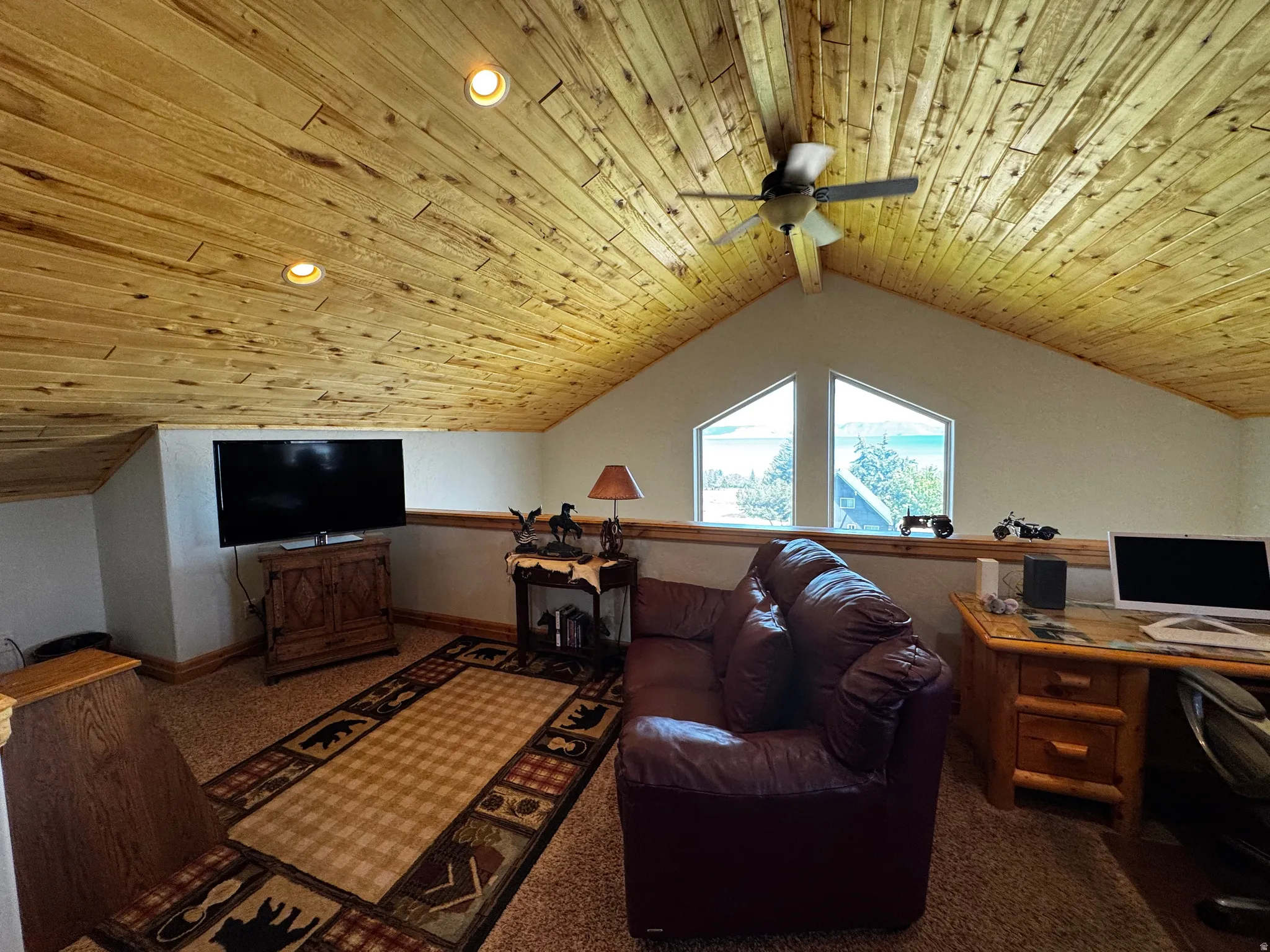 Vaulted wood-plank ceiling with recessed lighting and a ceiling fan