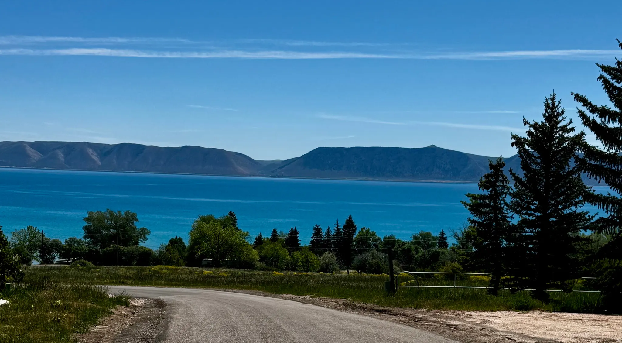Expansive water body with surrounding mountains and evergreen trees