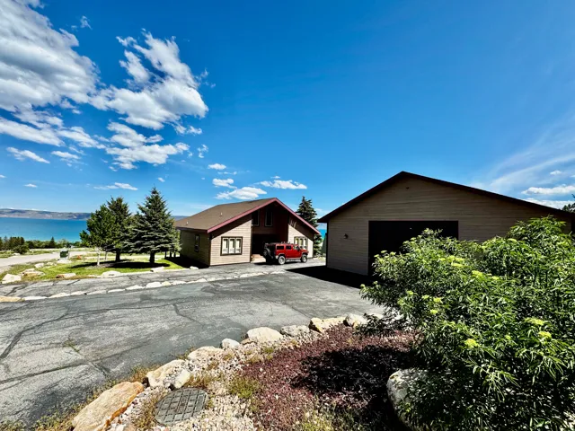 Property featuring a pitched roof, attached garage, and a separate detached garage structure
