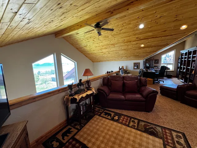 Vaulted wood-paneled ceiling with recessed lighting and ceiling fan