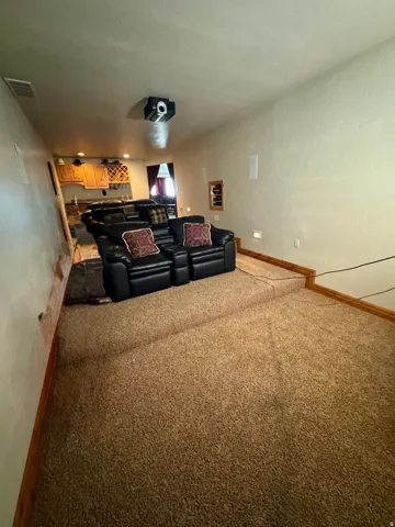 Tiered carpeted flooring with recessed wall lighting and ceiling-mounted projector