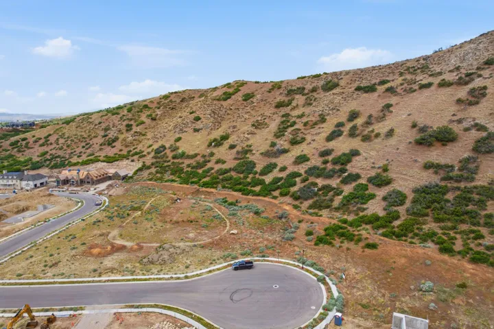 Hillside property featuring natural desert landscaping and paved roadways