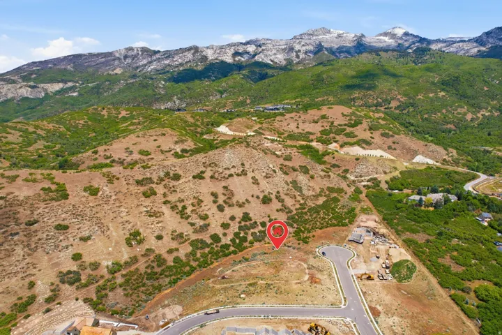 Expansive undeveloped lot featuring mountain scenery and a paved street