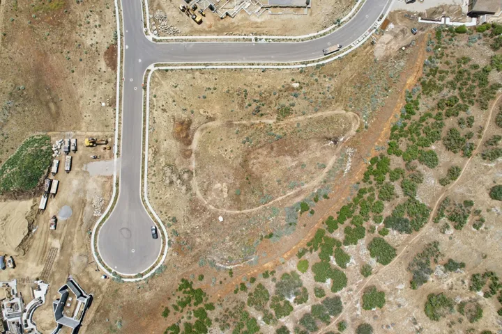 Expansive undeveloped land featuring a paved cul-de-sac and existing road infrastructure