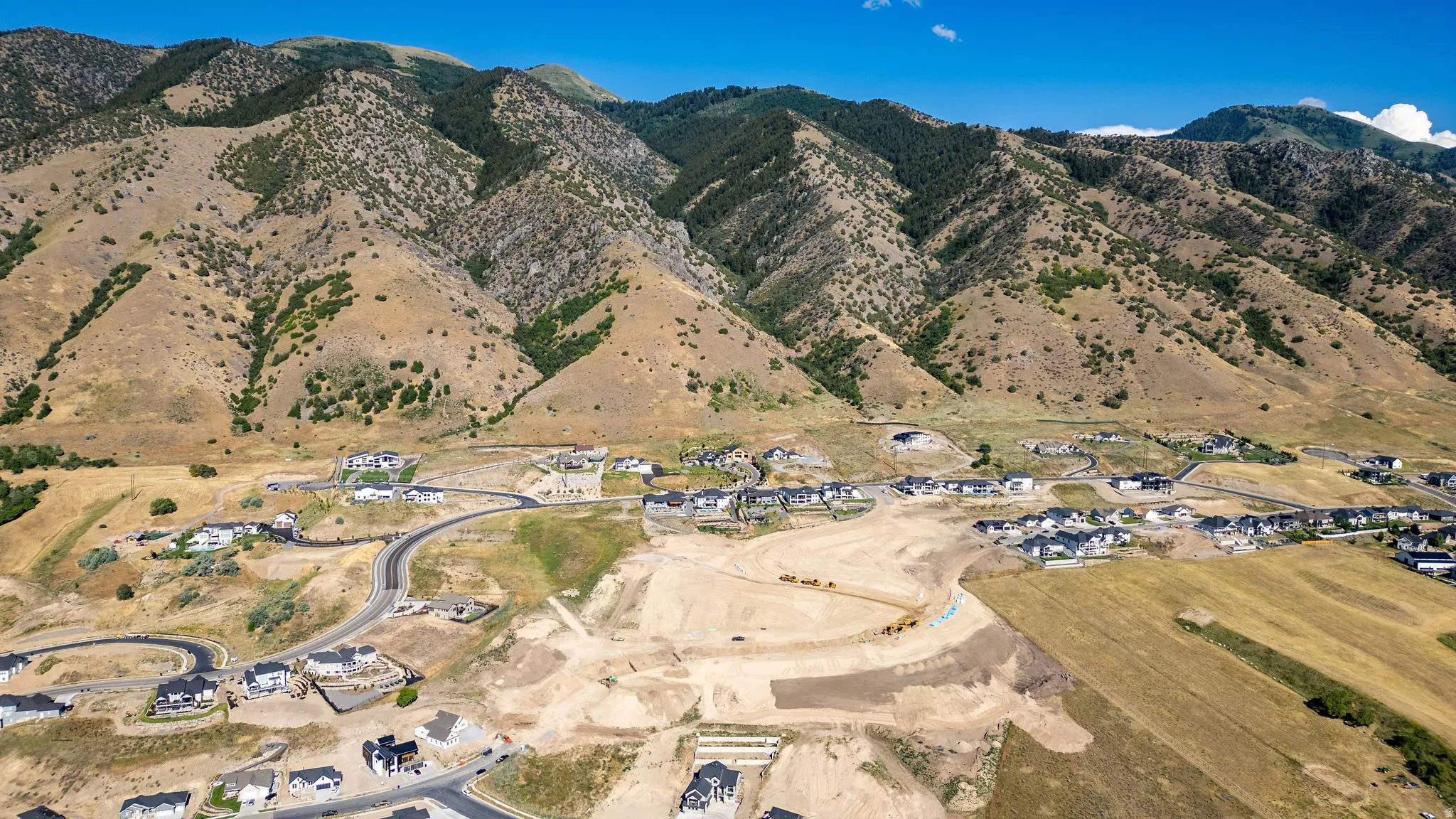 Expansive mountain backdrop with scattered new construction and developed roads