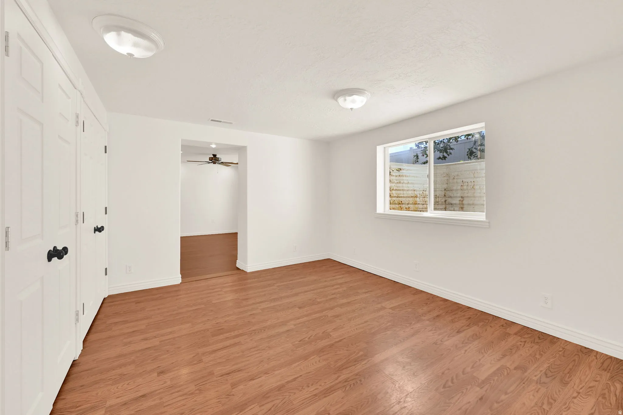 Bright room featuring wood-finish flooring and neutral wall tones