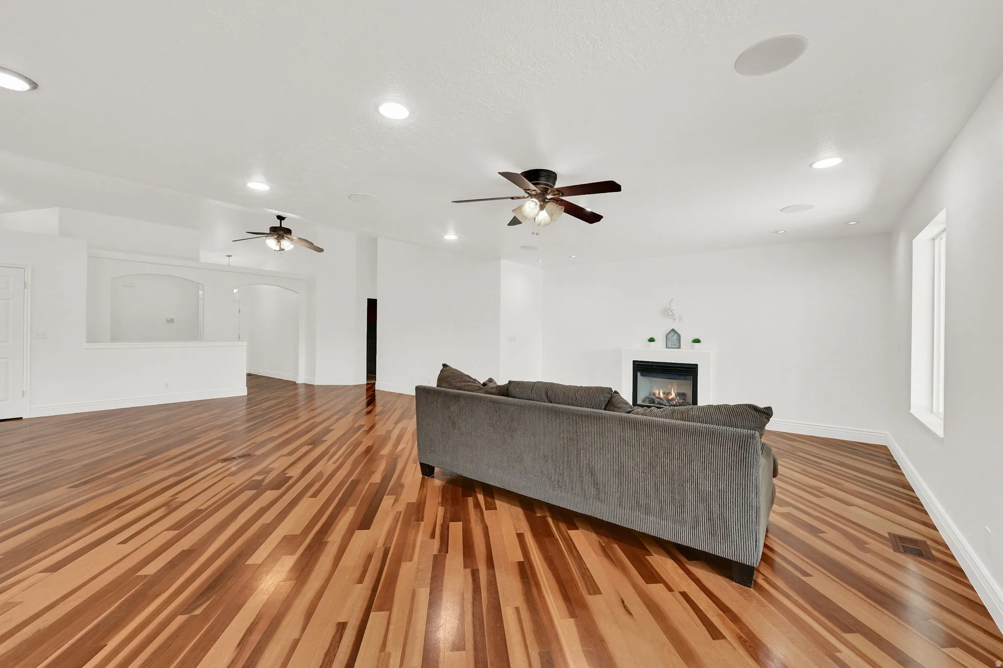 Open concept living area featuring wood-finish flooring, recessed lighting, and ceiling fans