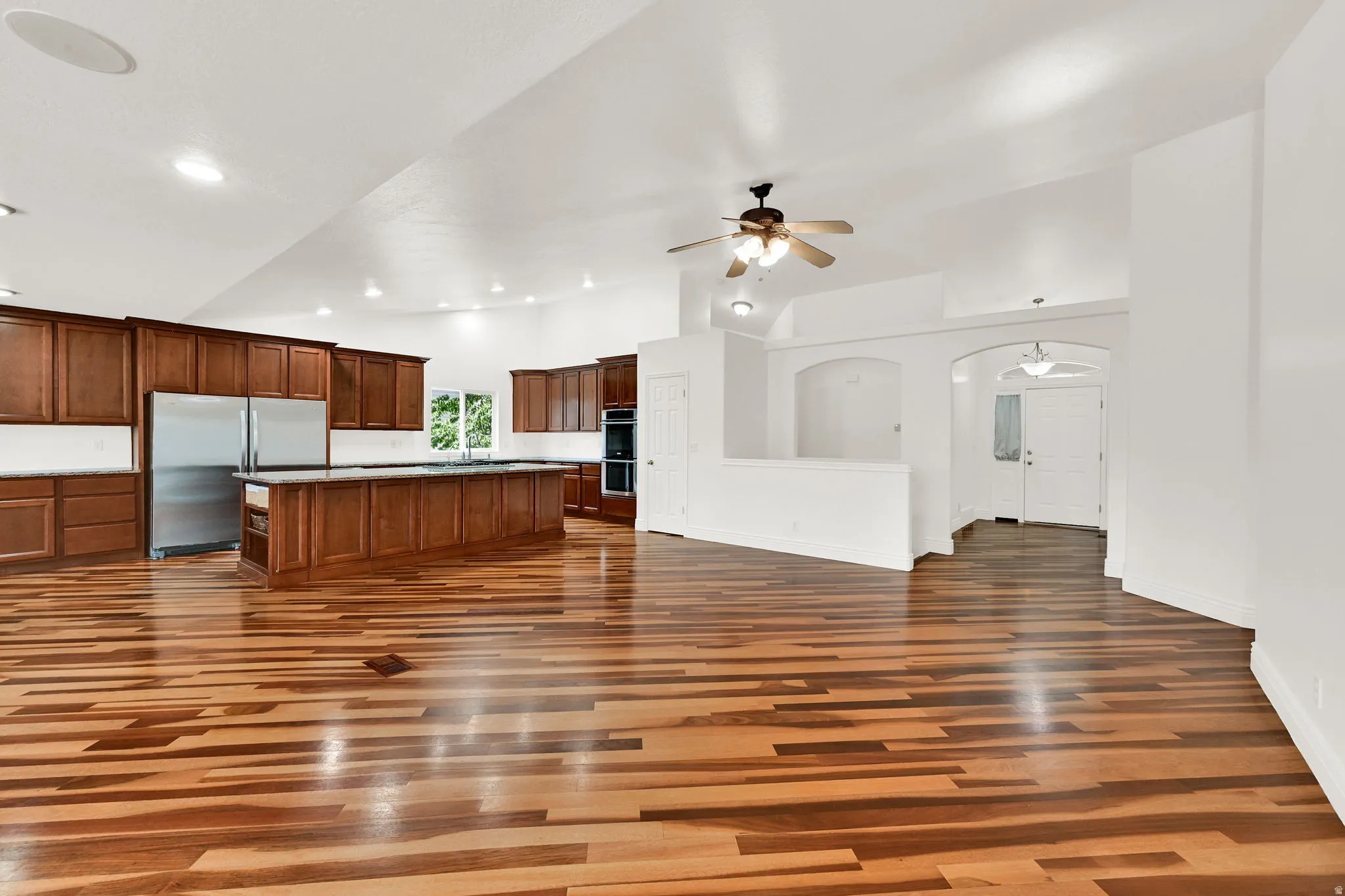 Spacious kitchen and living area featuring wood-finish flooring