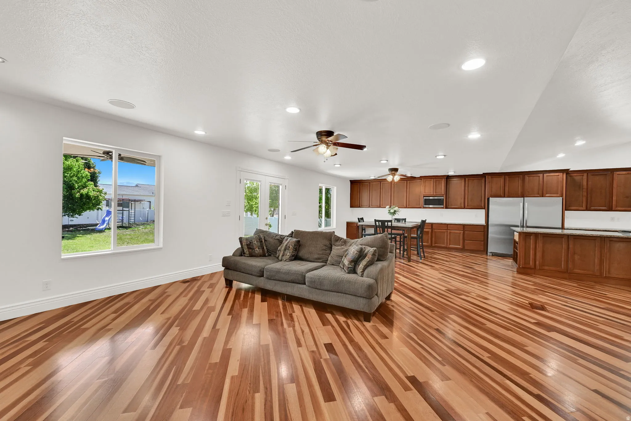 Spacious interior featuring wood-finish flooring, recessed lighting, and a kitchen with wood cabinetry