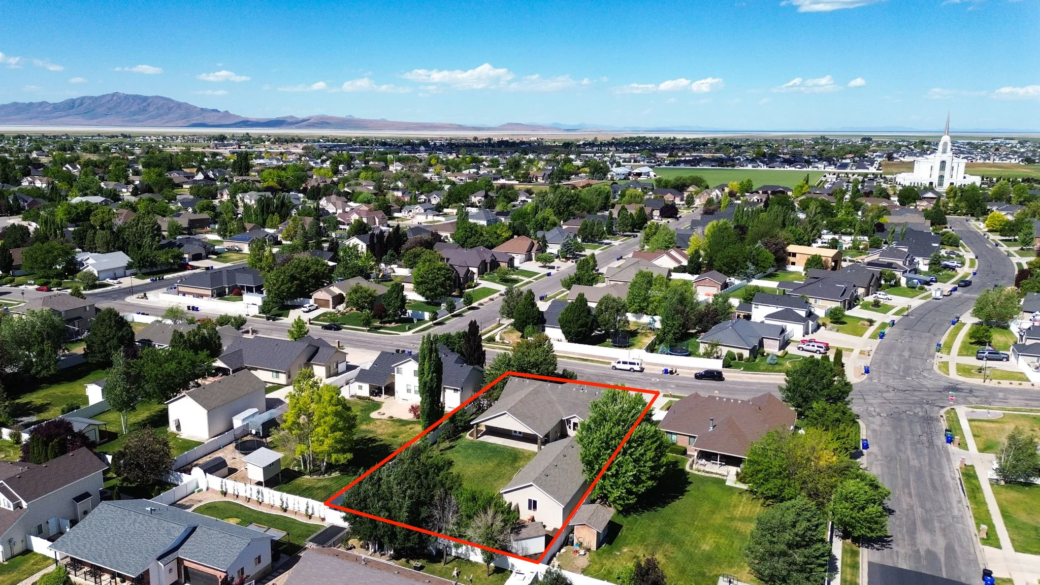 Spacious suburban property featuring a large backyard with mature trees, a multi-level house with an attached garage, and a detached shed
