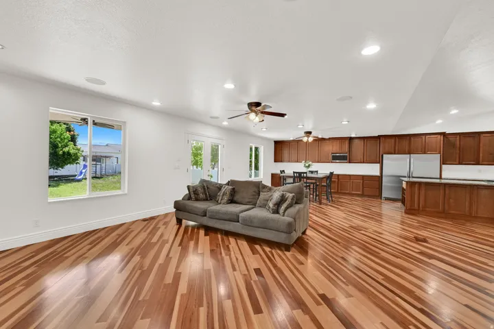 Spacious interior featuring wood-finish flooring, recessed lighting, and a kitchen with wood cabinetry