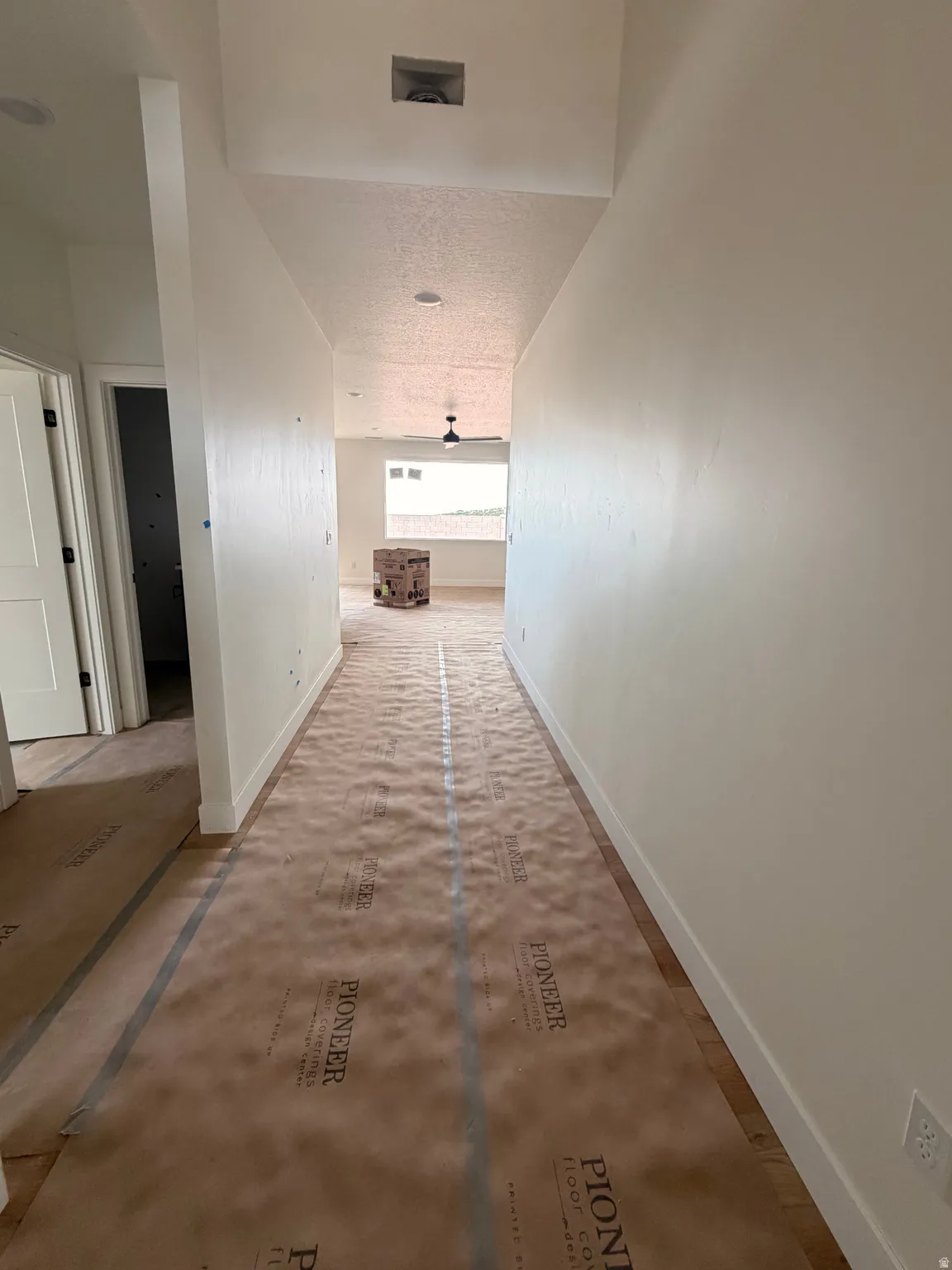 Hallway featuring wood-finish flooring, recessed lighting, and white baseboards