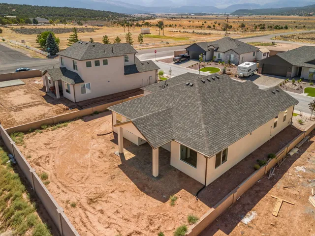 Newly constructed property featuring a stucco exterior and dark shingle roofing