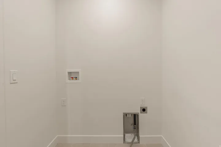 Utility room featuring multiple electrical outlets, a wall-mounted thermostat, recessed lighting, and concrete flooring