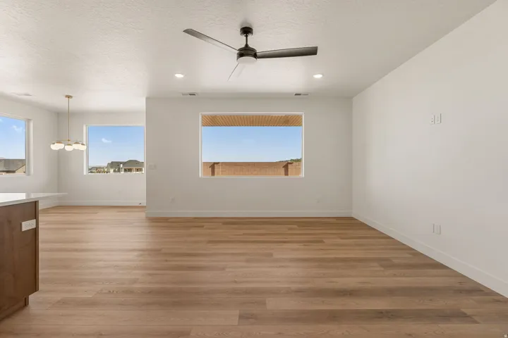 Open-concept living area featuring wood-finish flooring, recessed lighting, and a contemporary ceiling fan