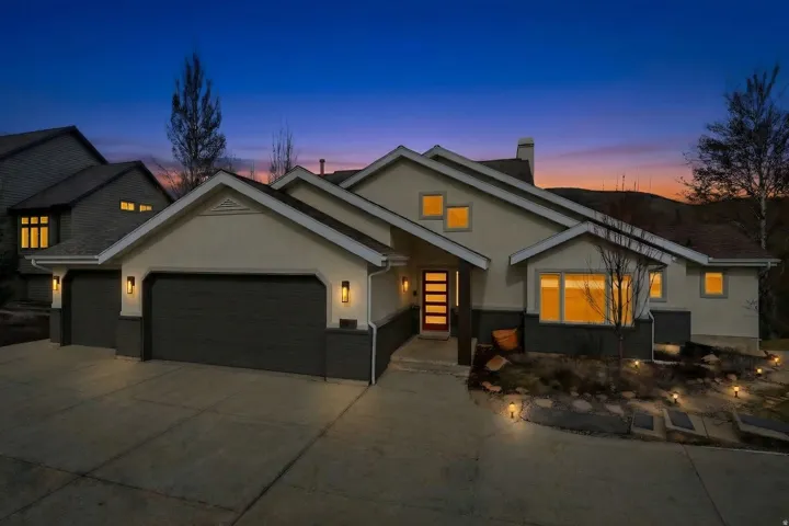 Contemporary stucco exterior with a three-car garage and a modern front entry door