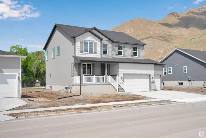 Contemporary two-story residence featuring a covered front porch with white railings and stone accents