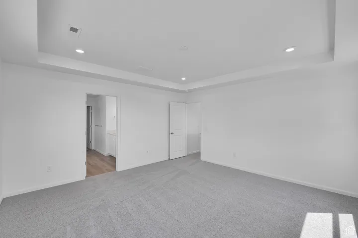Spacious interior with neutral gray carpeting and white walls