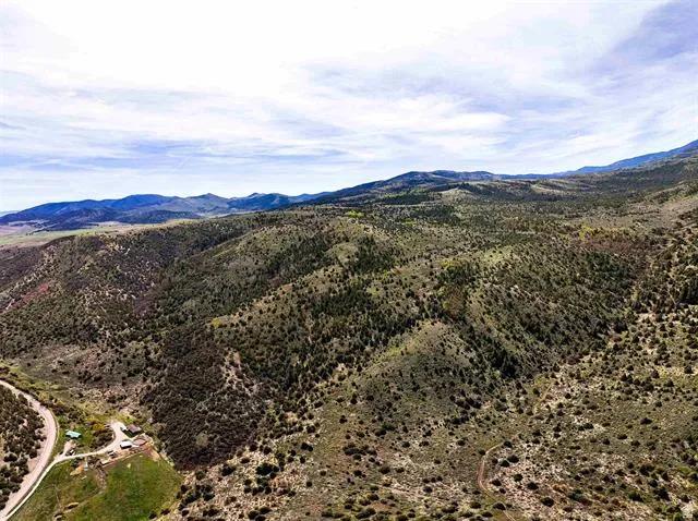 Expansive land parcel featuring diverse topography with rolling hills and distant mountains