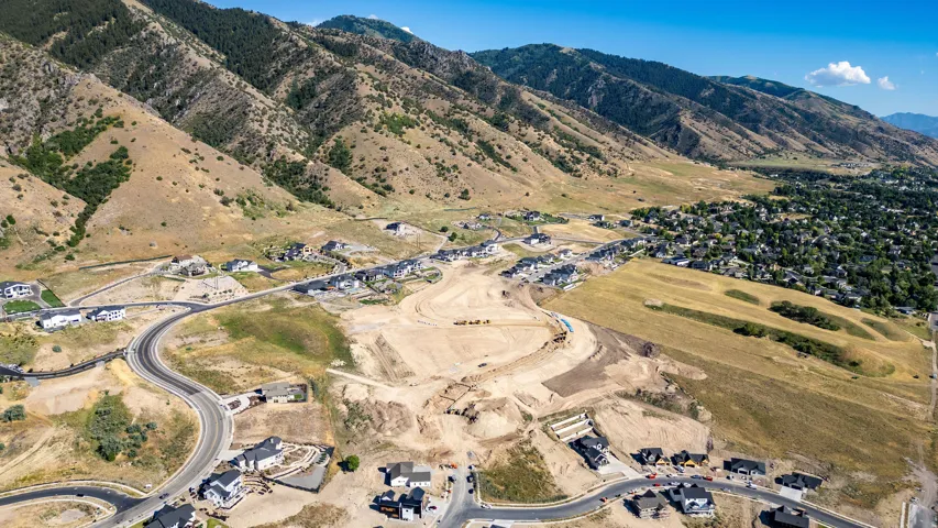 Aerial perspective highlighting a developing residential community at the base of expansive, natural terrain