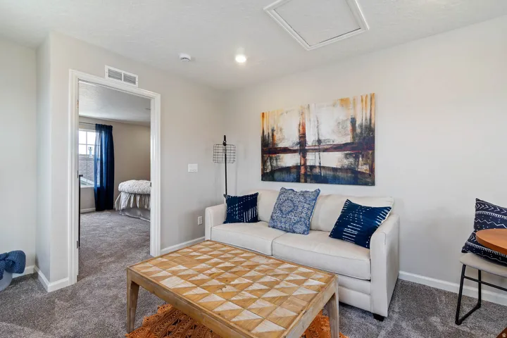 Carpeted room with a doorway opening into an additional carpeted room