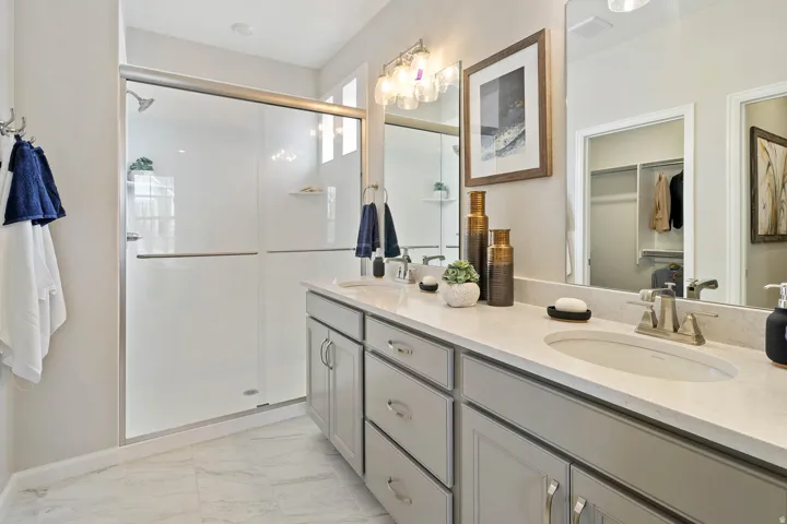 Double vanity with integrated sinks, light-toned countertop, and undermount cabinetry