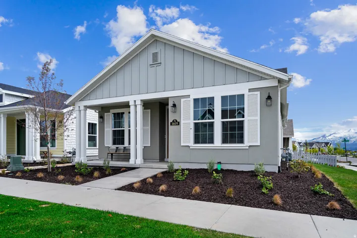 Contemporary gray exterior featuring white board and batten siding, decorative shutters, and a covered porch