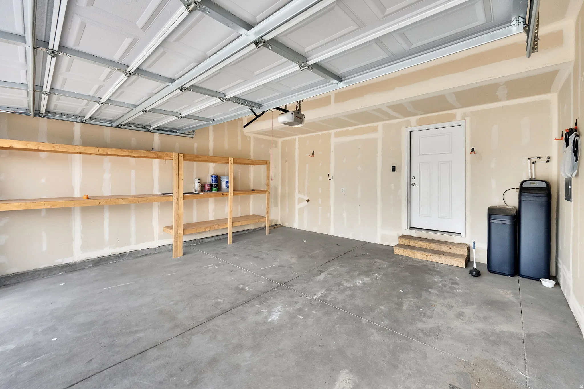 Spacious garage with exposed panel ceiling and concrete flooring
