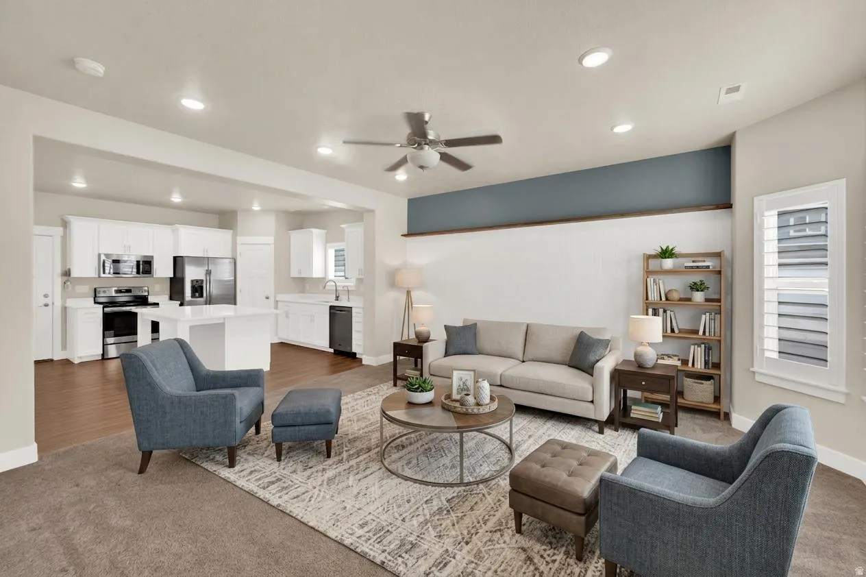 Open-concept living space featuring a ceiling fan, recessed lighting, and ample natural light from a window with plantation shutters