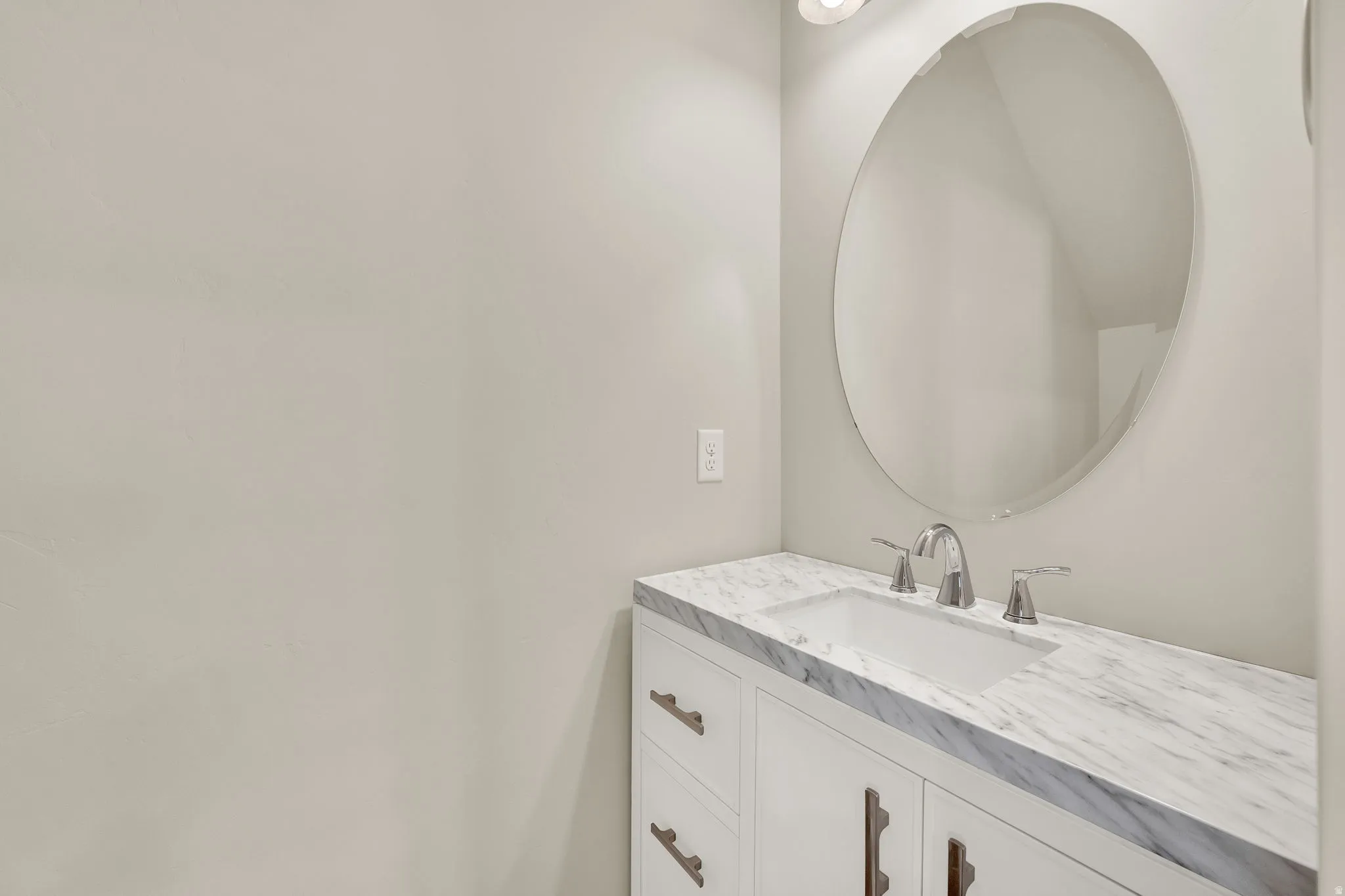 White vanity with an integrated rectangular sink, marble countertop, and chrome faucet