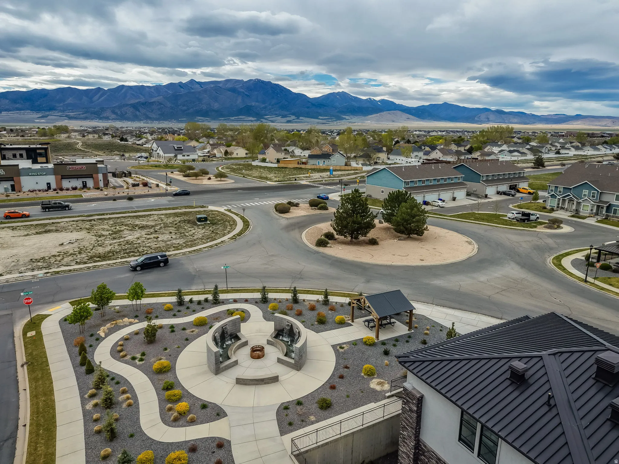 Community gathering space featuring a central fire pit, surrounding stone benches, and decorative landscaping