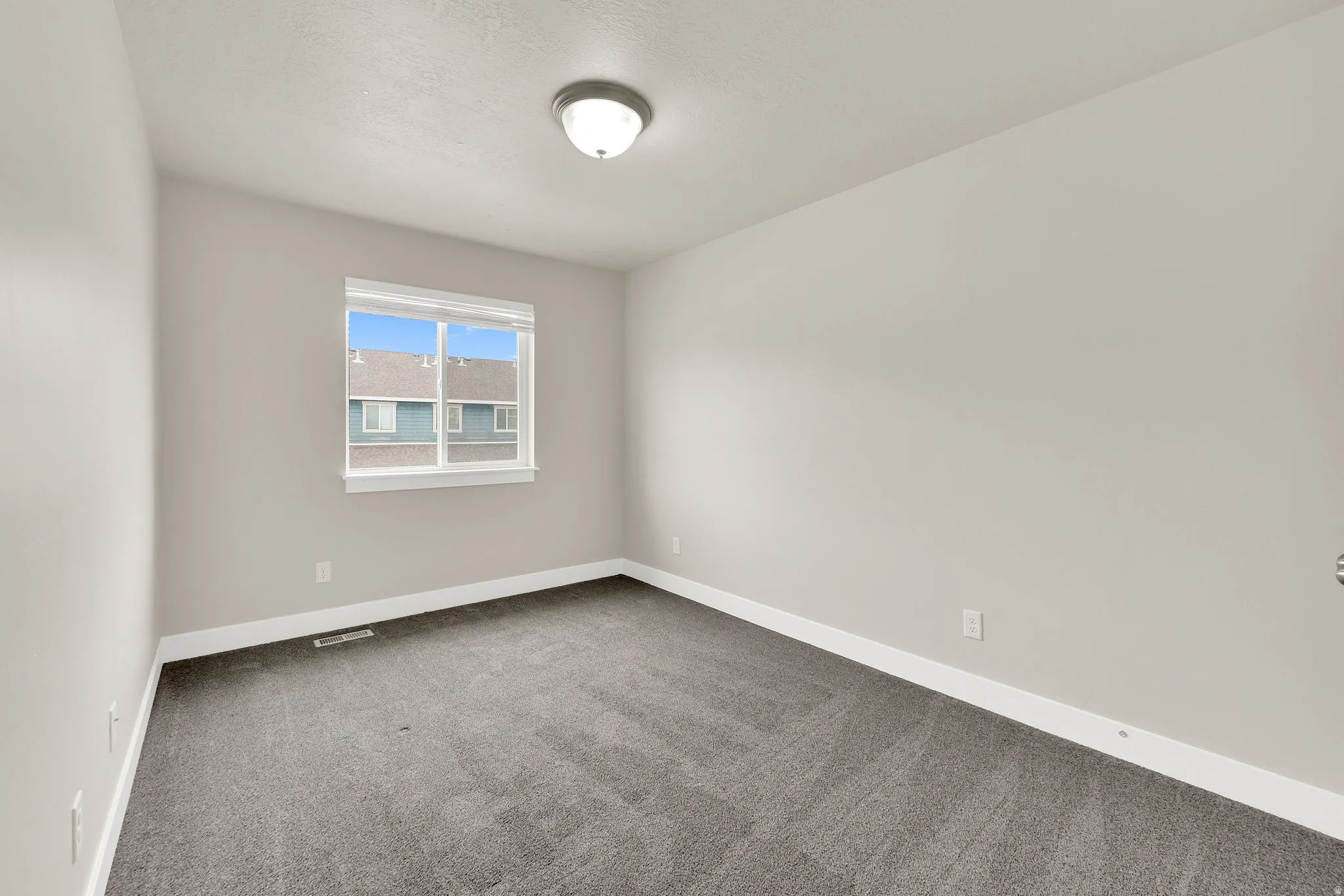 Room featuring gray wall-to-wall carpeting, white baseboards, and light gray painted walls
