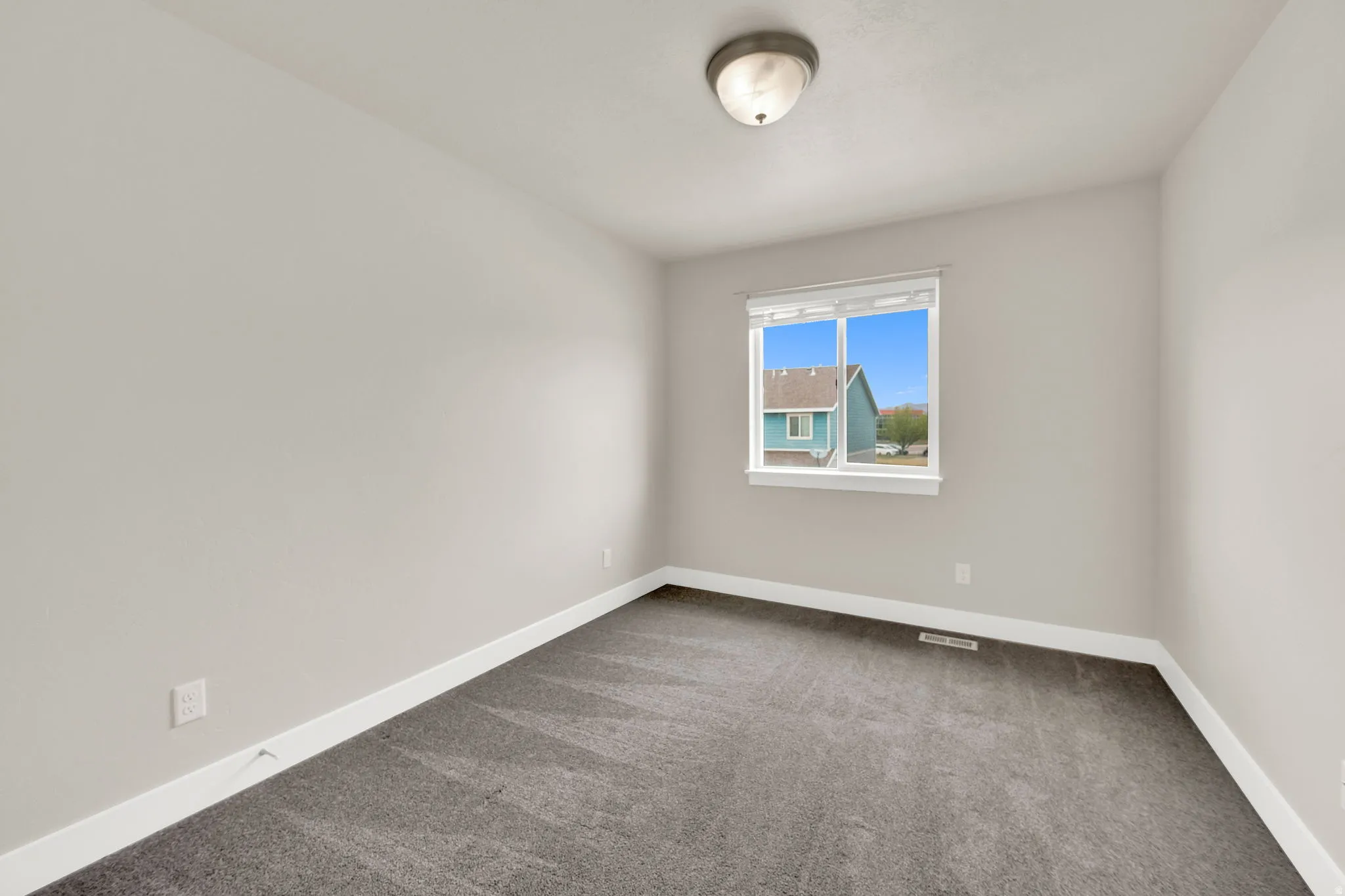 Neutral toned walls and patterned gray carpeting define this room