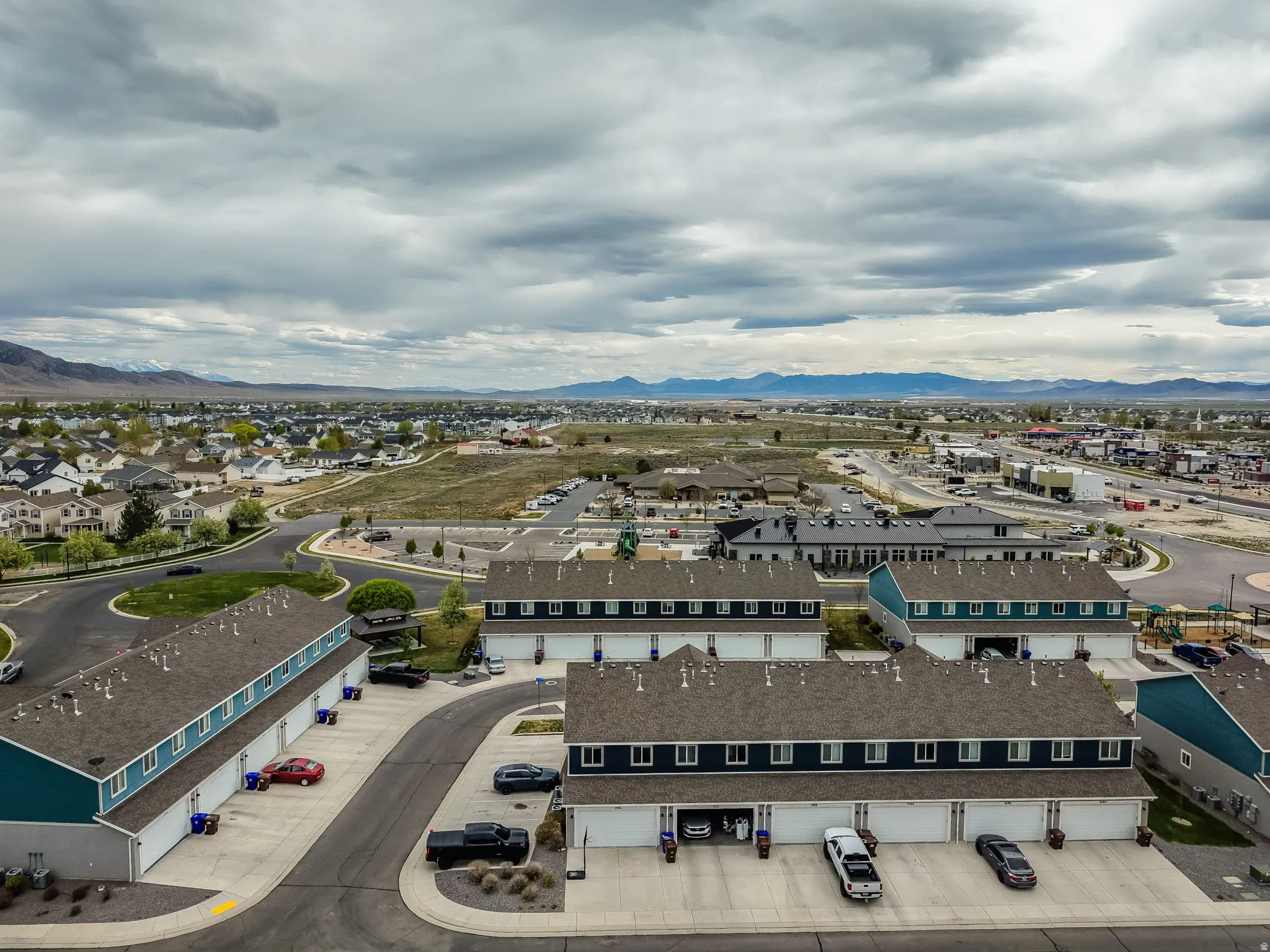 Aerial perspective showcasing multiple townhouse-style buildings with attached garages and paved driveways