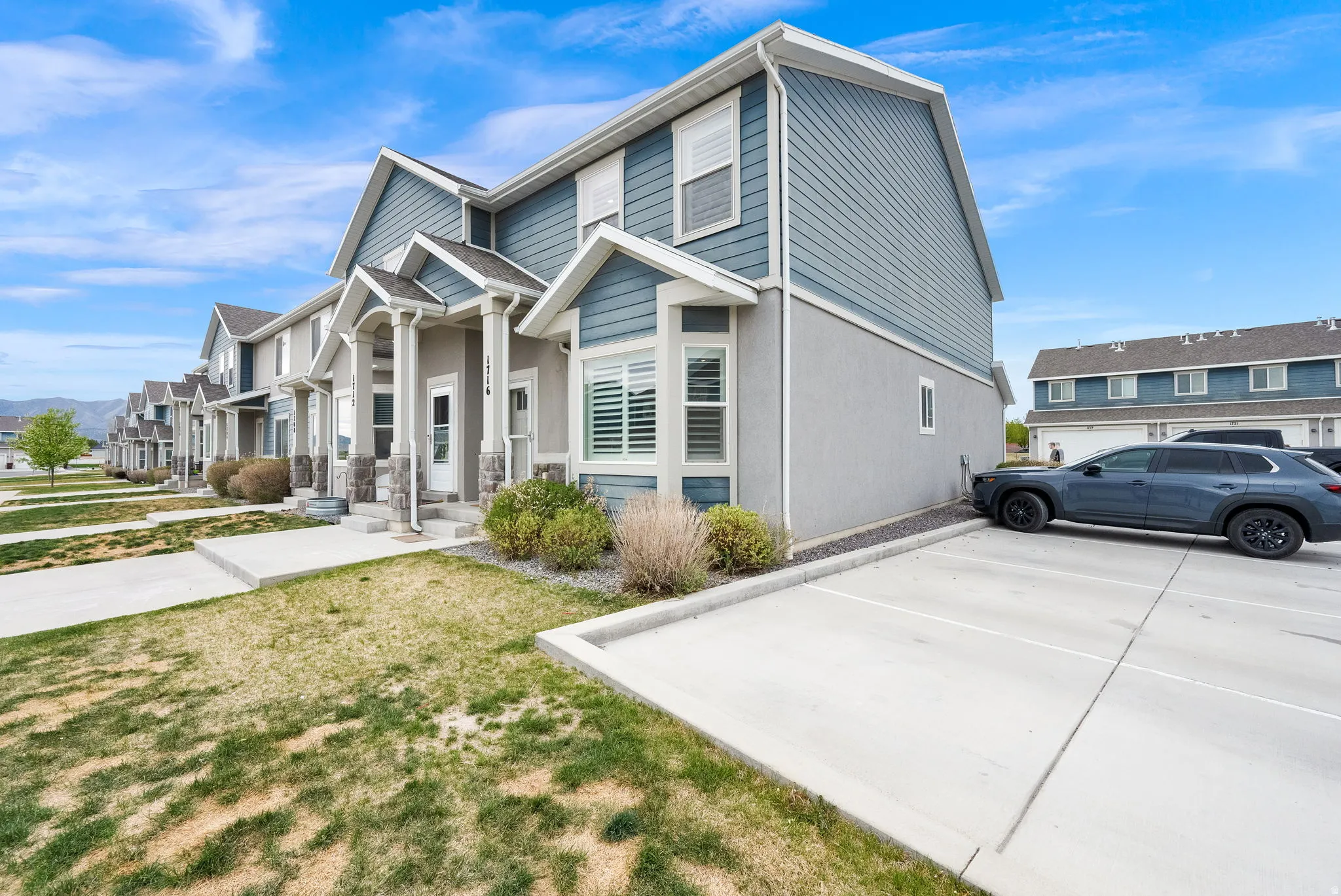 Modern townhome exterior featuring blue siding, stucco, and stone accents