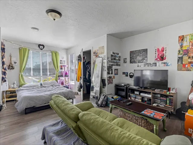 Spacious room featuring wood-finish flooring and multiple windows providing natural light