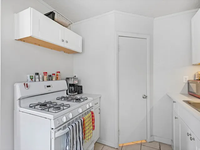 Compact kitchen area featuring a white gas range