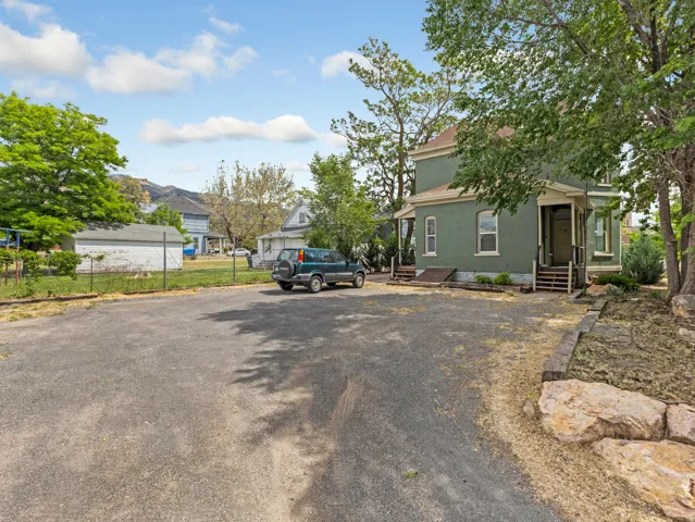 Spacious gravel parking area with mature trees.