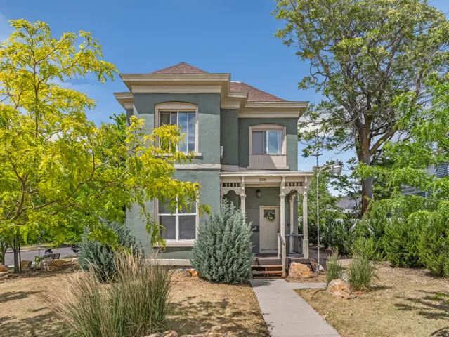 Two-story stucco exterior with decorative trim, a covered front porch, and a brown shingle roof
