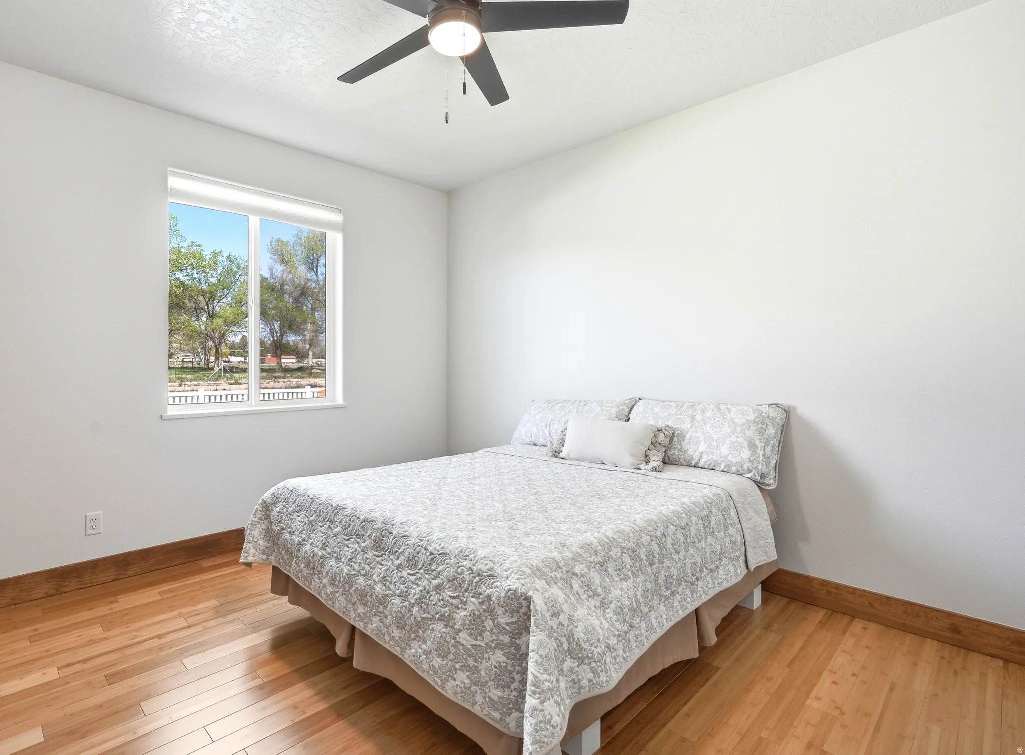 Bright, comfortable space featuring warm bamboo flooring, modern finishes, a new fan and oversized windows.