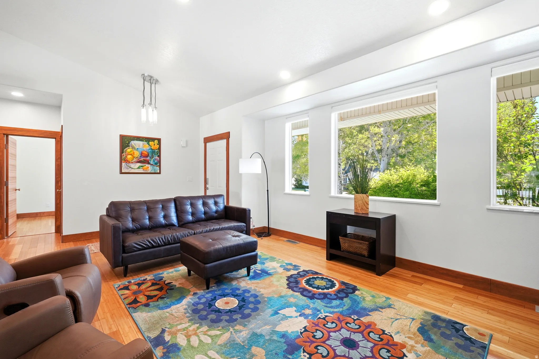 Comfortable living space with warm bamboo floors, abundant sunlight, and an open, welcoming feel.