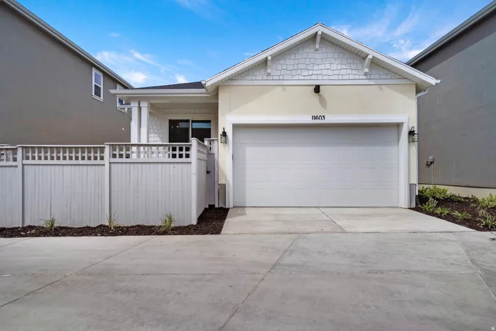 Contemporary single-story exterior featuring a light-colored stucco finish, white shake siding accents, and an attached two-car garage