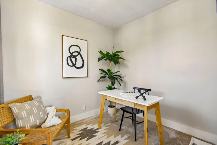 Neutral wall finishes compliment wood-finish flooring with a geometric area rug