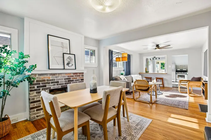 Dining area with a brick fireplace and wood-finish flooring