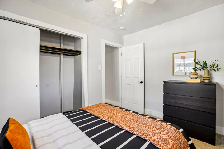 Bedroom with light gray walls, white trim, and a ceiling fan
