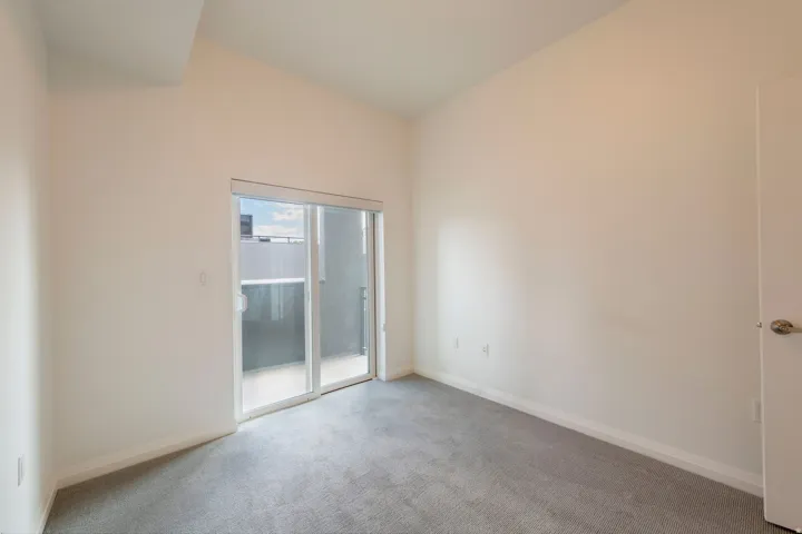 Neutral wall finishes with a sliding glass door leading to an exterior balcony