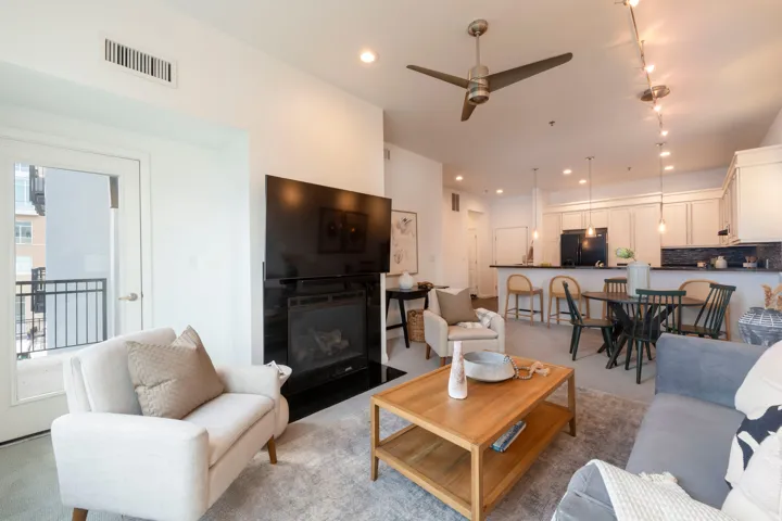 Open-concept living space featuring a built-in fireplace, a ceiling fan, and recessed lighting