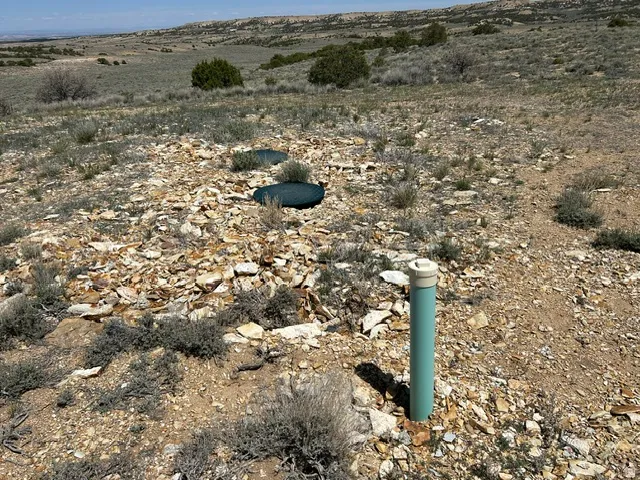 Expansive open terrain featuring natural rock formations and arid vegetation